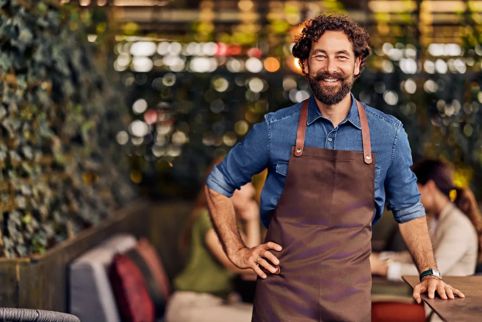 Gerente de restaurante en el salón mientras el equipo prepara el servicio