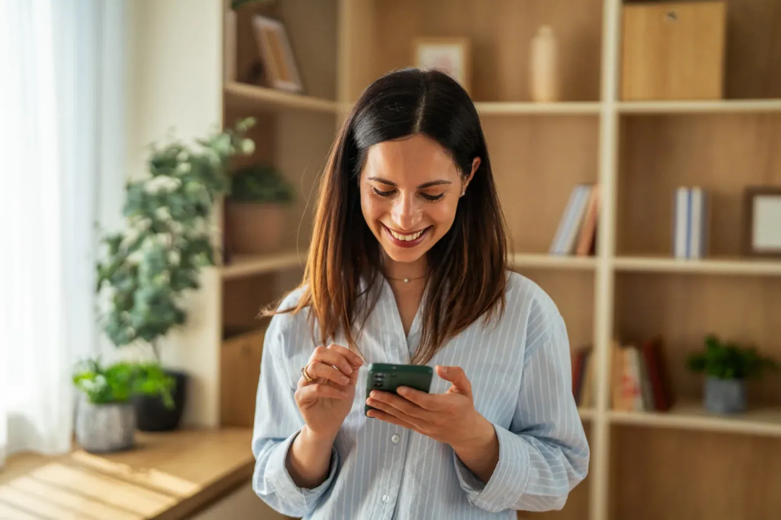 Colaboradora sonriendo mientras gestiona sus solicitudes desde el celular con Naaloo